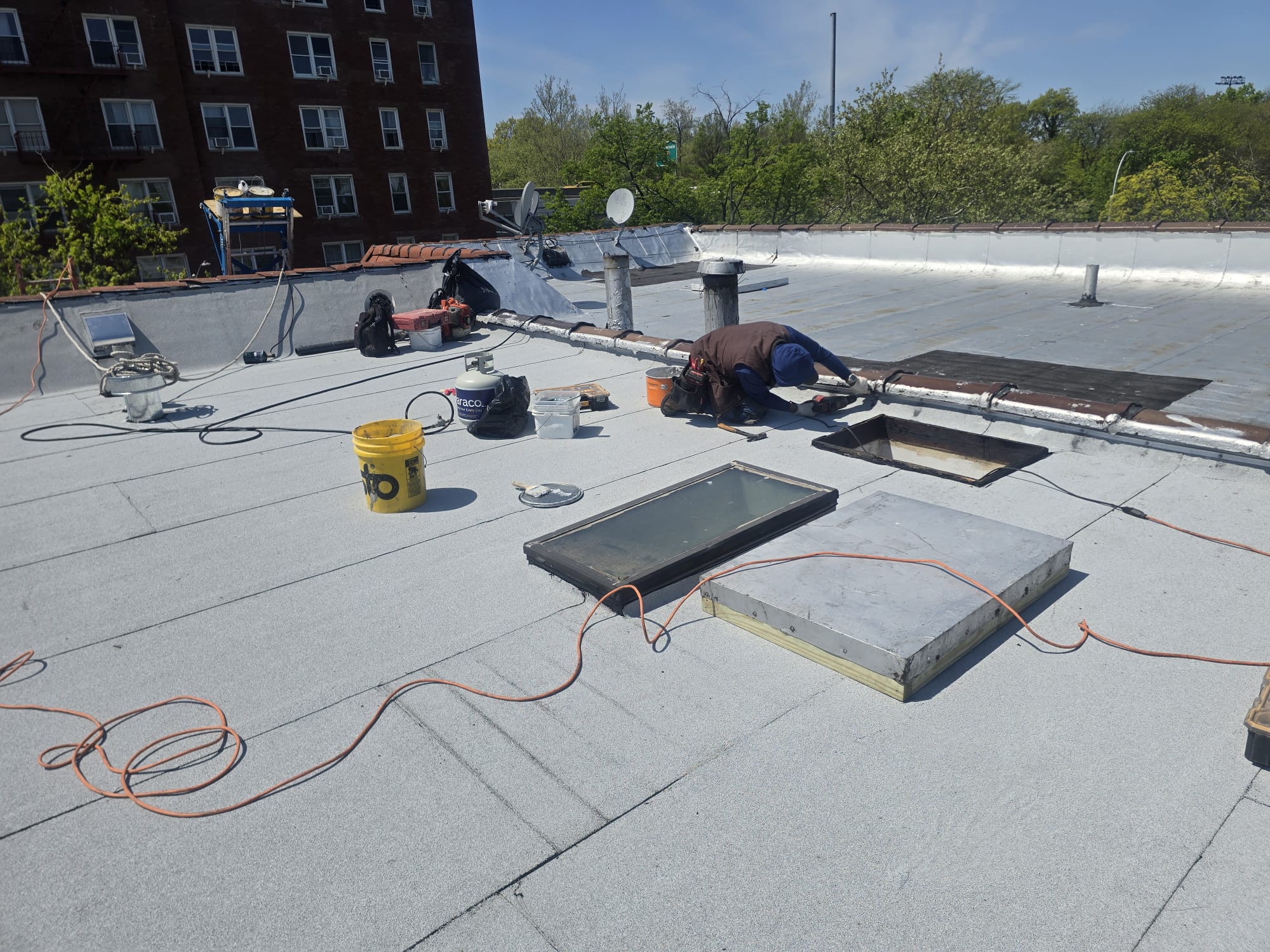 North Star roofing worker on a flat commercial roof with tools and materials
